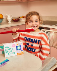 Enfant avec une brosse à dents et Ma Boîte Stop Caries